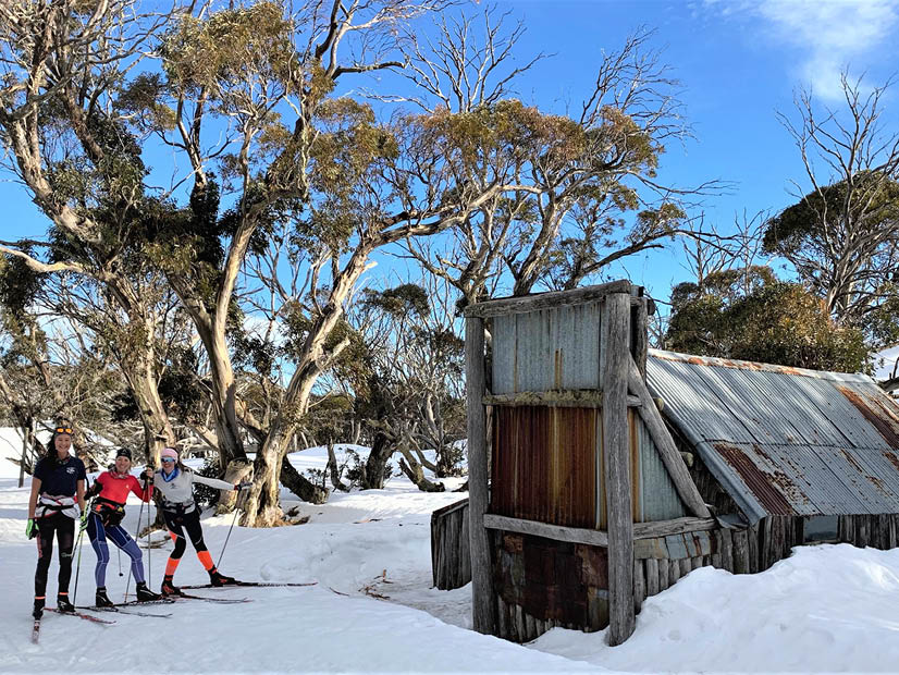 Skiers standing in front of Wallaces Hut Alpine National Park Falls Creek