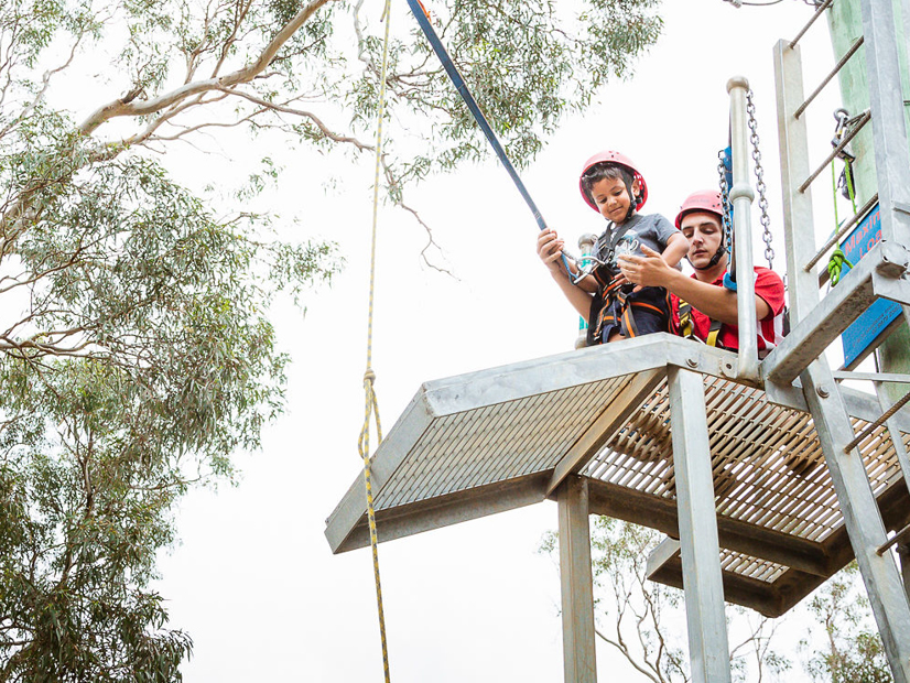 A camp participant is preparing to use the giant swing.